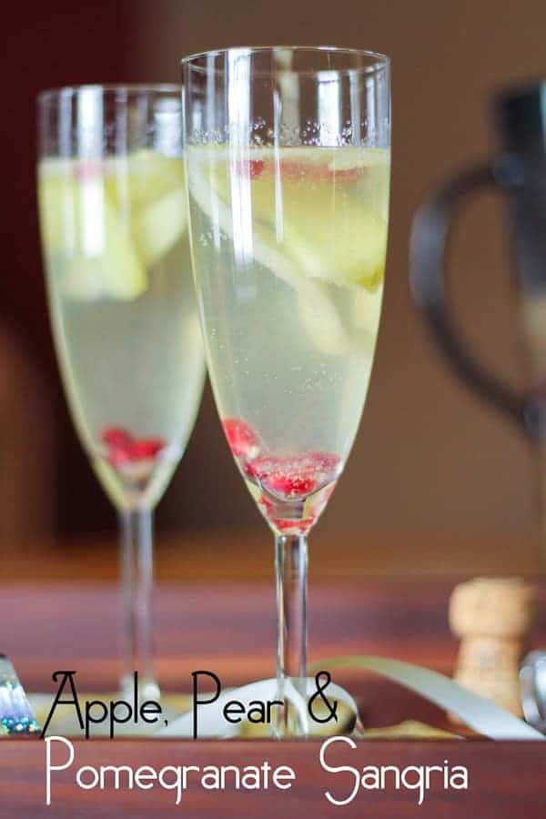 Apple Pear and Pomegranate Sangria in two champagne flutes