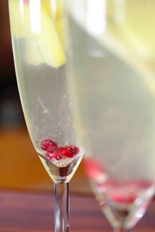 close up view of Apple Pear and Pomegranate Sangria in champagne flutes