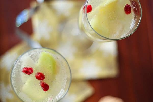 overhead view of Apple, Pear and Pomegranate Sangria in champagne flutes