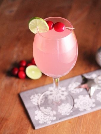 cranberry ginger fizz in wine glass on wood table