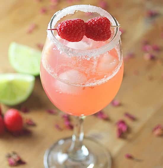 raspberry rosewater gin rickey in glass with lime in background