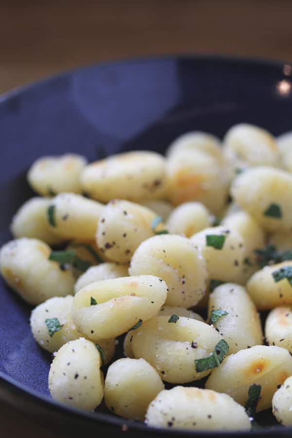 Pile of Gnocchi with Sage and Black Pepper in a blue bowl