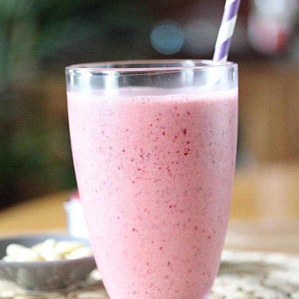 side view of cherry almond smoothie with purple straw