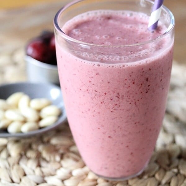 cherry almond smoothie with almonds and fresh cherries in background