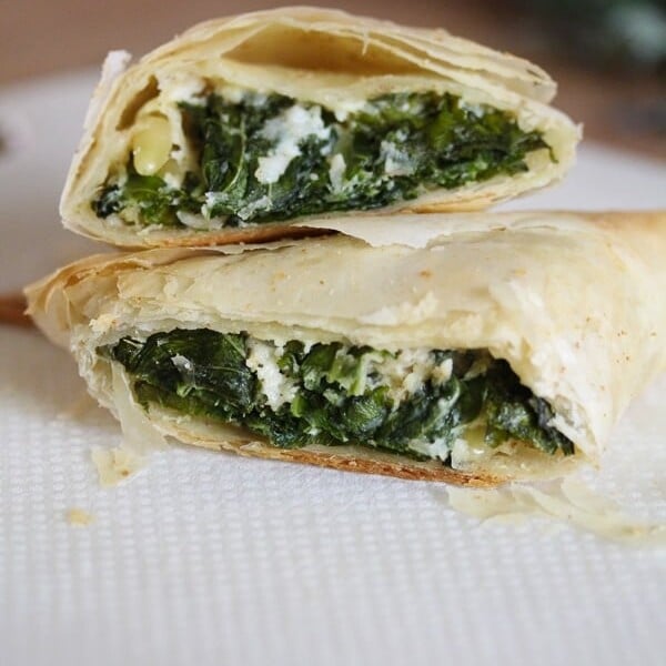 two kale spanakopitas cut in half