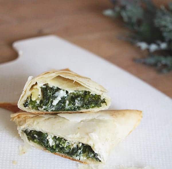 Close up view of Kale Spanakopitas cut in half to see the kale and cheese inside