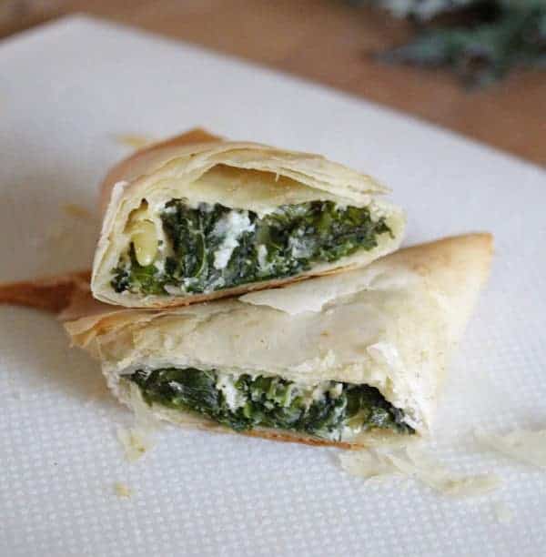 Close up view of Kale Spanakopitas cut in half to see the kale and cheese inside
