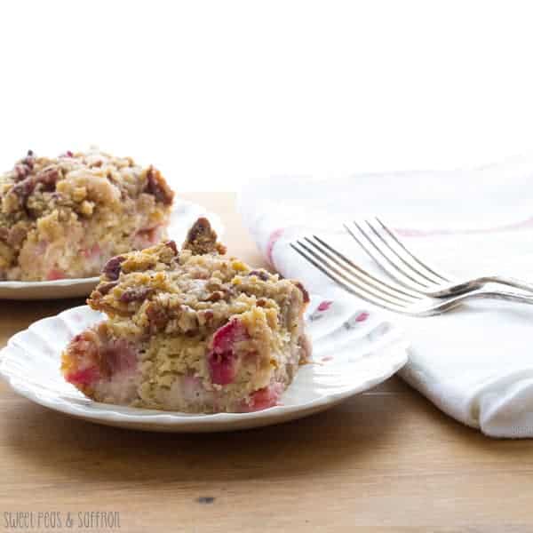 Two pieces of Rhubarb Buttermilk Coffee Cake with a Nutmeg and Pecan Streusel on white plates