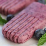 two blueberry mint yogurt pops on white plates