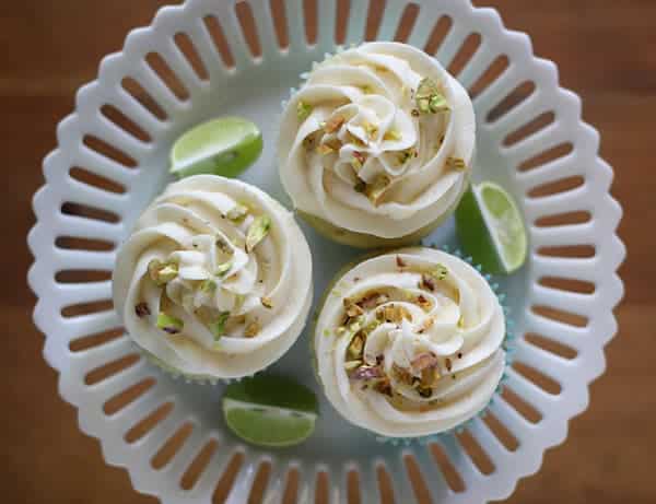 Overhead shot of Key Lime Cupcakes with White Chocolate Frosting on a white cake stand