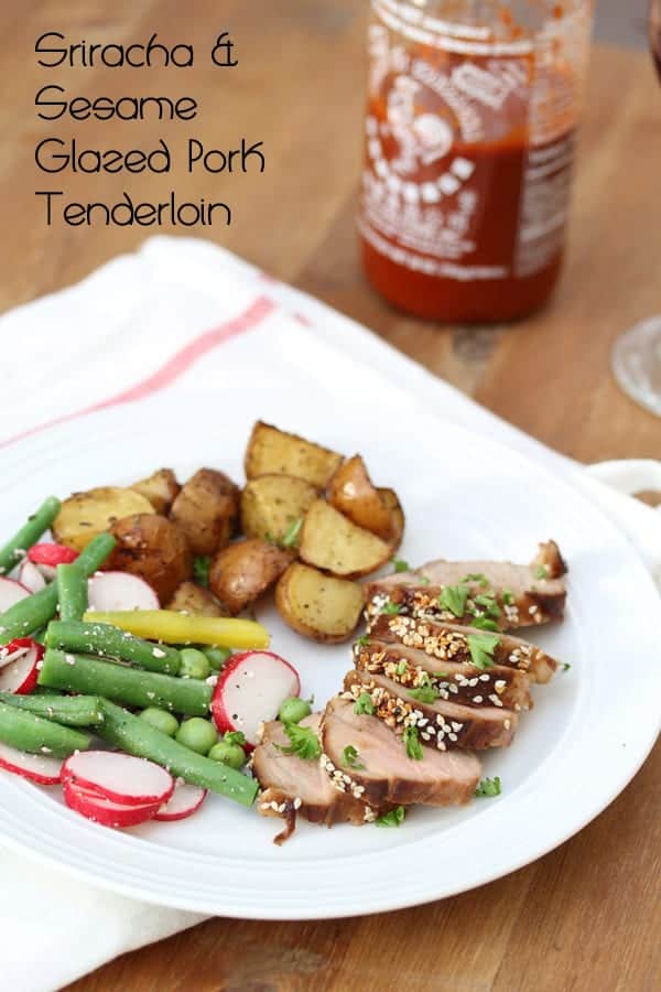 Glazed Pork Tenderloin sliced on plate with roasted potatoes and fresh vegetables