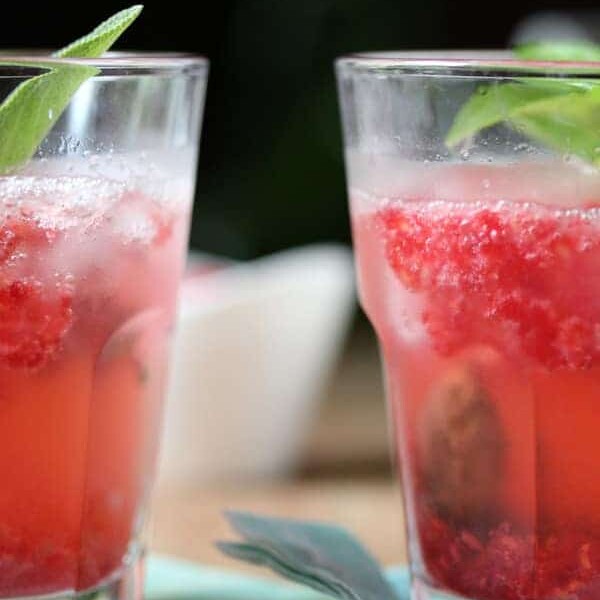 two raspberry smash cocktails on blue napkin