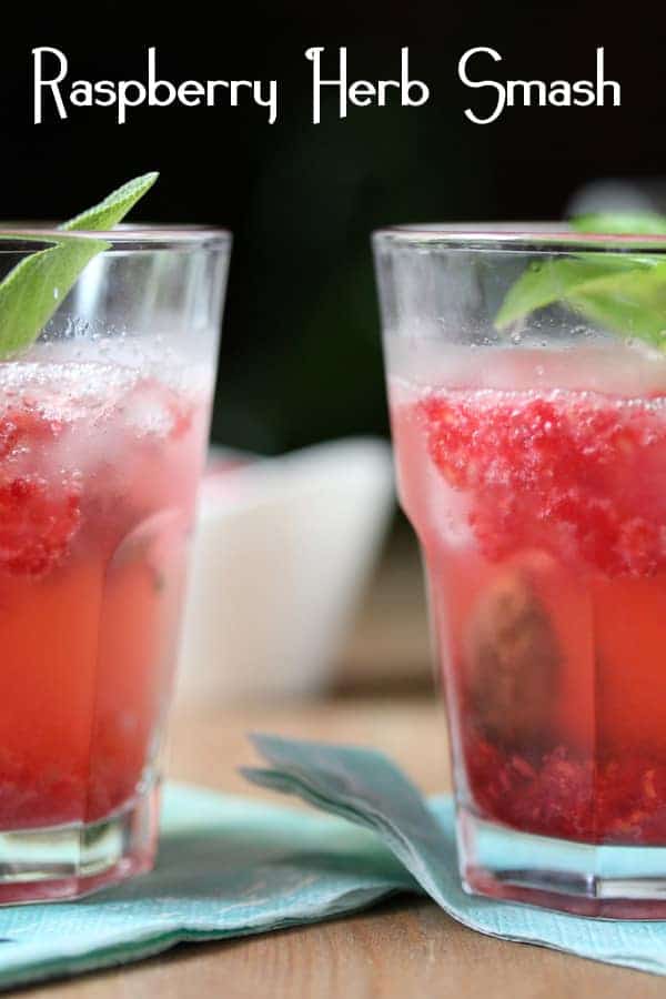 Raspberry Smash Cocktail in two glasses with fresh herb garnish