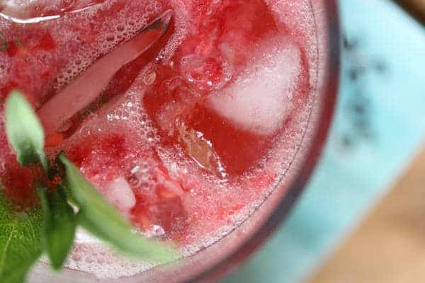 Close up view of Raspberry Herb Smash Cocktail in glass