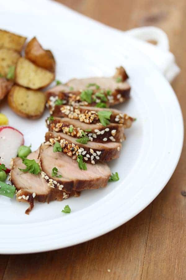 Close up shot of Sriracha and Sesame Glazed Pork Tenderloin on white plate