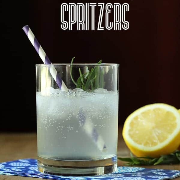 lemony tarragon spritzer in glass with cut lemon and straw