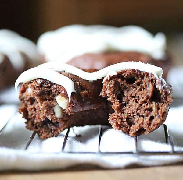 Close up shot of Chocolate Zucchini Donut with bite taken out of it and white chocolate icing on top