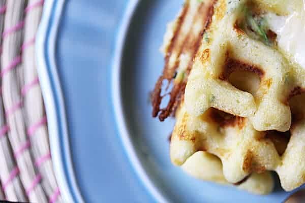 Close up view of the Zucchini and Cheddar Waffles on a blue plate