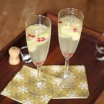 two apple pear and pomegranate sangria glasses on wood tray