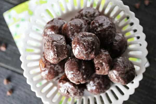 Overhead view of Chocolate Glazed Donut Holes in a white serving dish