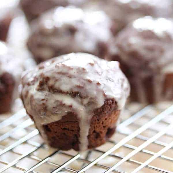 Close up shot of a Chocolate Donut Hole on a wire rack with glaze