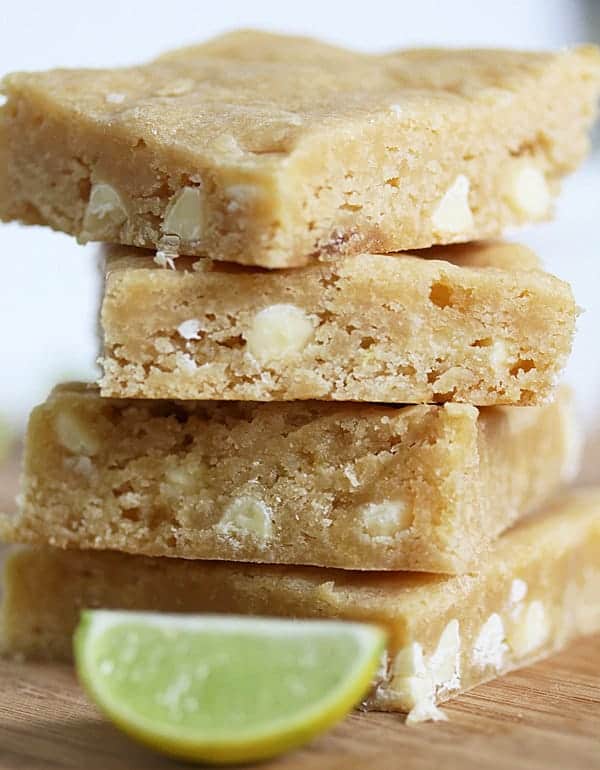 Stack of four Key Lime Blondies with a fresh lime wedge in front of them