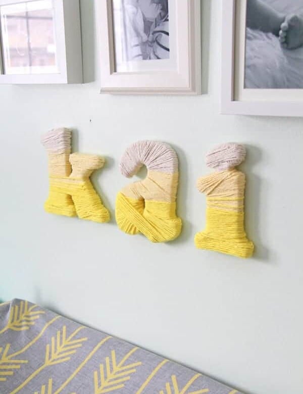 DIY ombre yarn wrapped letters on wall spelling kai
