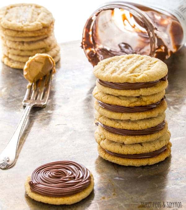 Stack of Peanut Butter Sandwich Cookies with empty jar of Nutella behind them