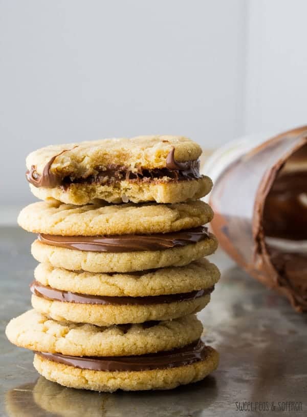 Stack of Nutella and Peanut Butter Sandwich Cookies with a bite taken out of the top cookie