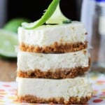 stack of three tequila lime cheesecake bars with lime slice on top
