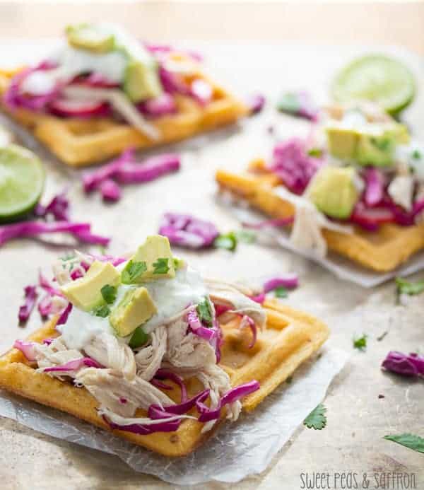 Three Waffle Tostadas with Chicken and Lime Crema on a piece of parchment paper