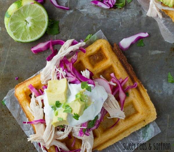 Chipotle-Overhead view of Waffle Tostadas with Chicken, avocado chunks and Lime Crema on parchment paper