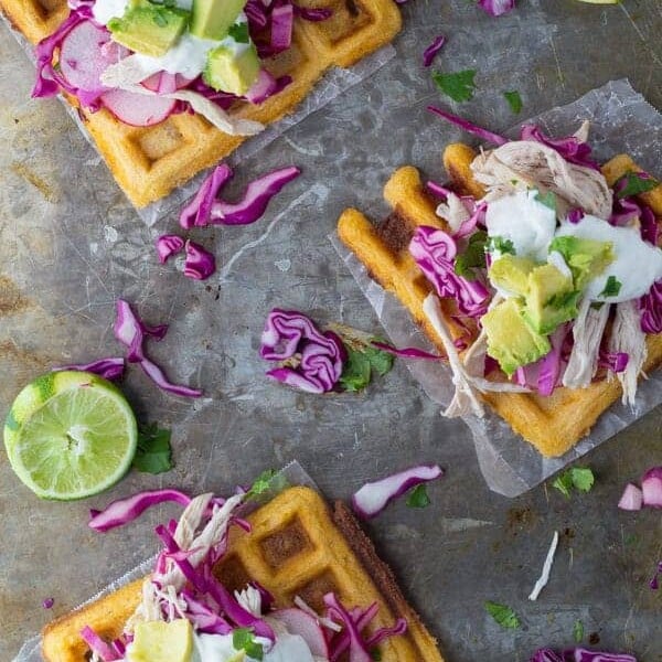 overhead shot of chipotle cornmeal waffle tostadas with chicken and lime crema
