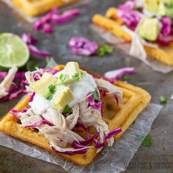 Waffle Tostadas with Chicken and Lime Crema on parchment paper with half a lime next to it