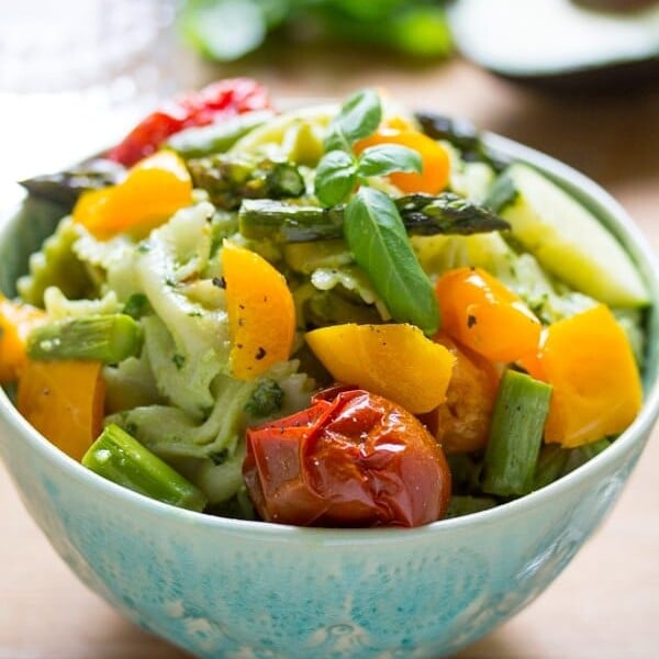side angle view of avocado pesto pasta salad in a bowl