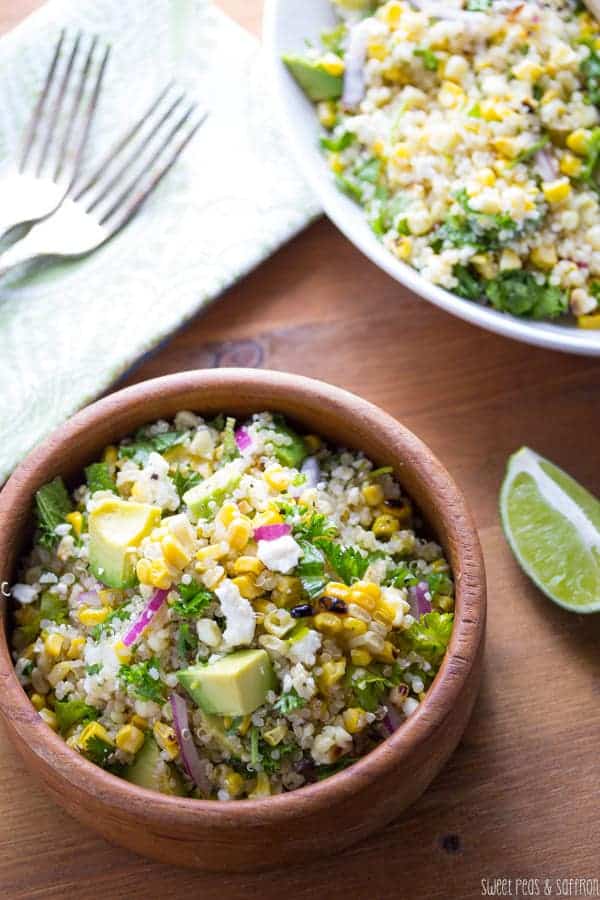 Charred Corn Salad in a wood bowl with fresh lime wedge on the side