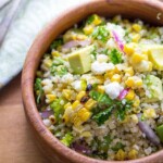 overhead view of charred corn salad with feta, mint and quinoa in large wooden bowl