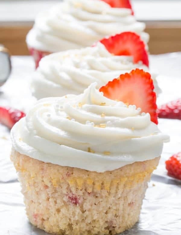 three strawberry cupcakes with chapagne frosting