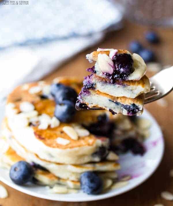 Close up shot of Almond Blueberry Pancakes with a bite taken out on fork
