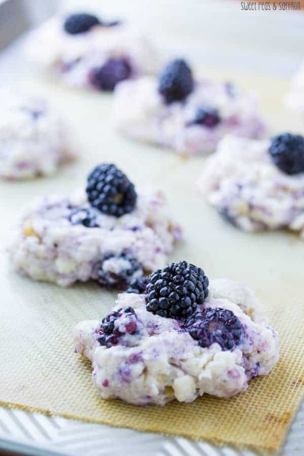Close up shot of blackberry scones on silicone baking mat with fresh blackberries on top