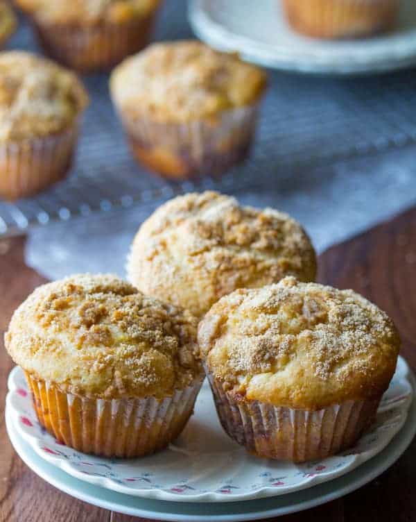 Three Apple Coffee Cake Muffins with a buttery brown sugar crumble arranged on a plate