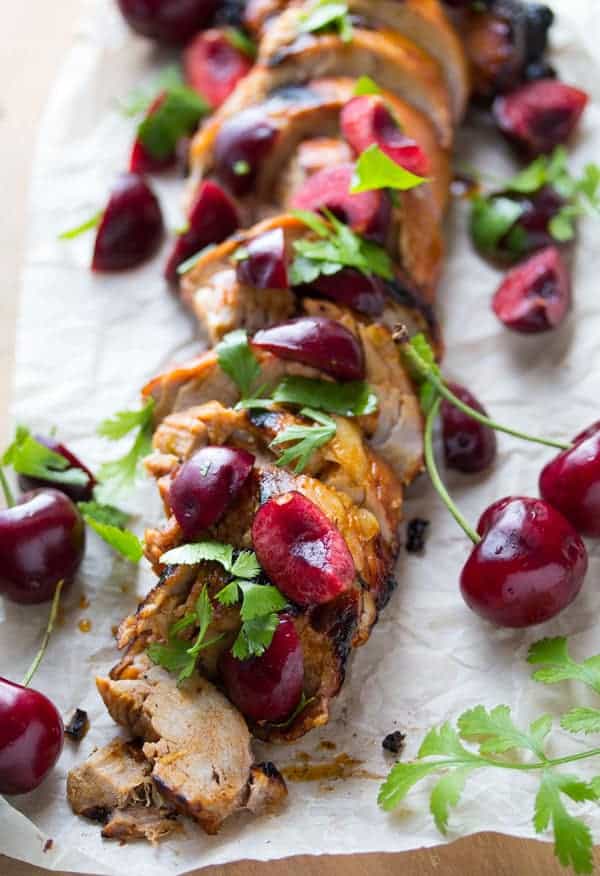 Chipotle Grilled Pork Tenderloin Sliced on Parchment Paper with cherries