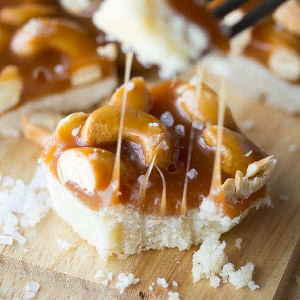 salted caramel bars with cashews on wood board