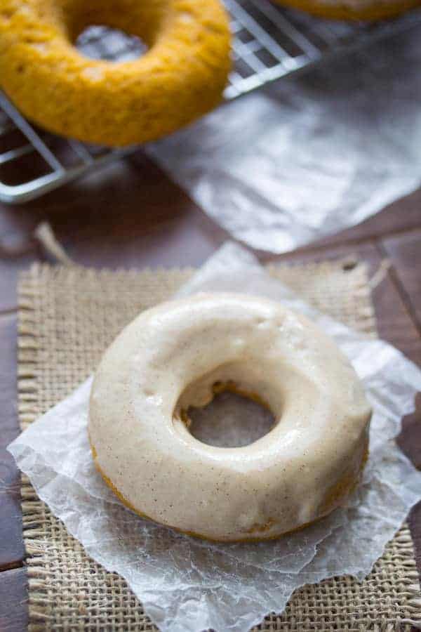 Baked Pumpkin Donut with Cream Cheese Frosting on a piece of parchment paper