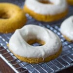 baked pumpkin donuts with cream cheese on wire rack
