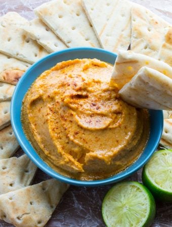 smokey sweet potato hummus in blue bowl with sliced pitas