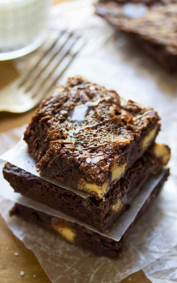 Stack of three Salted Caramel Brownies with parchment paper between