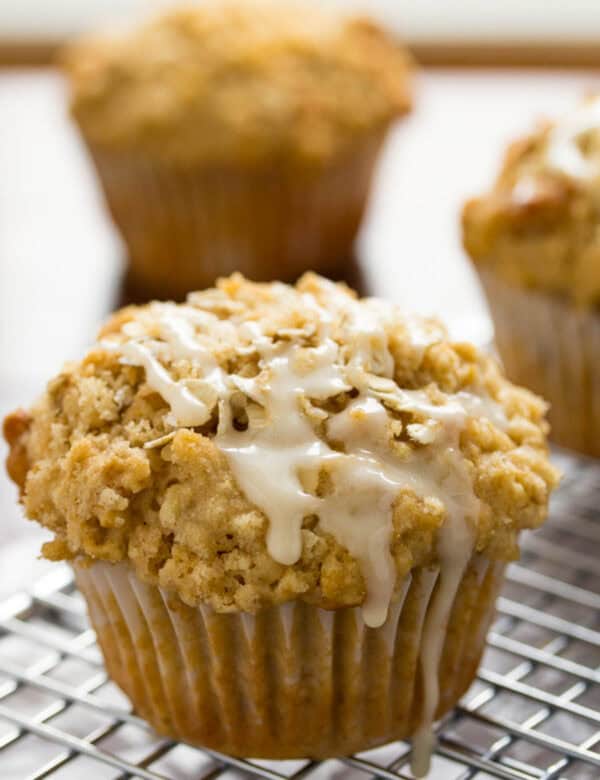 a close up shot of oatmeal muffins with a glaze dripping off the top