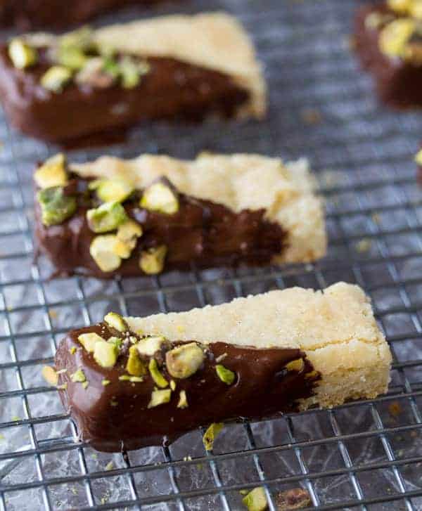 close up view of Chocolate Dipped Cardamom Shortbread Cookies with pistachios