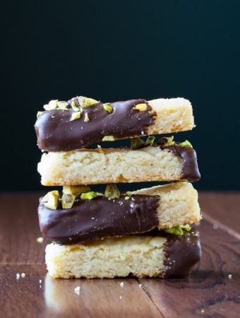 stack of four cardamom and chocolate shortbread cookies with salted pistachios